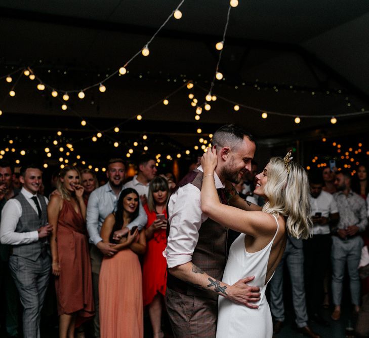 Bride and groom first dance with festoon light canopy