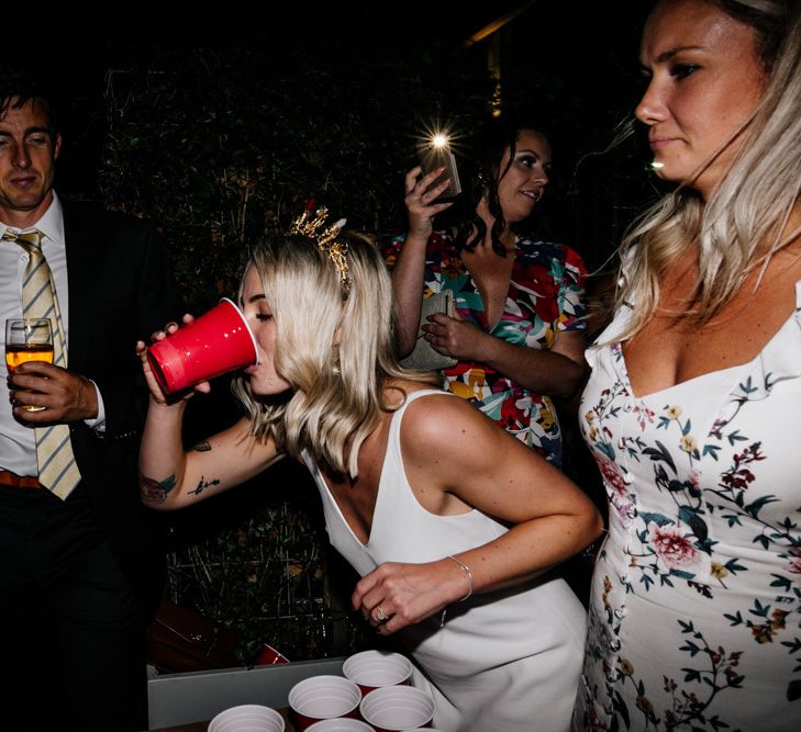 Bride drinking during beer pong game