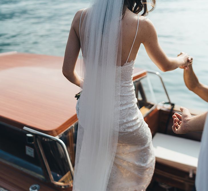 Bride in Grace loves Lace Mia Wedding Dress and Cathedral Length Veil Getting onto Boat on Lake Como