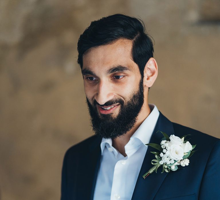 Groom in Taliare Navy Suit Reading His Vows