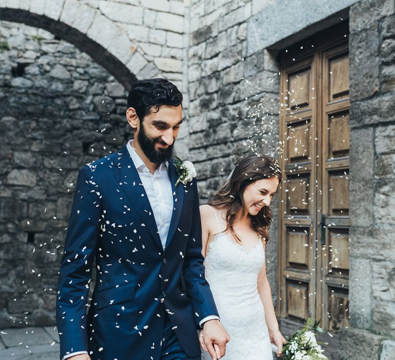 Confetti Exit with Bride in Grace Loves Lace Mia Wedding Dress and Groom in Taliare Navy Suit