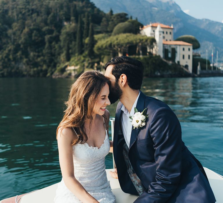 Laughing Bride in Grace Loves Lace Mia Wedding Dress and Groom in Taliare Navy Suit Enjoying a Boat Ride Over Lake Como