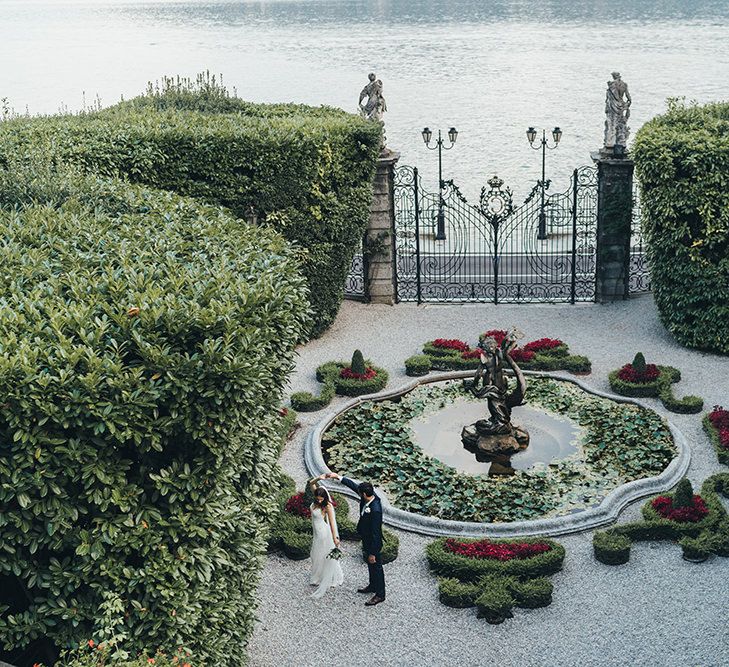 First Dance in a Garden with Bride in Grace Loves Lace Mia Wedding Dress and Groom in Taliare Navy Suit