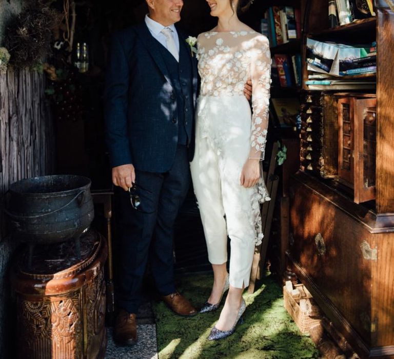 Bride wearing appliqué wedding jumpsuit at relaxed outdoor wedding in autumn