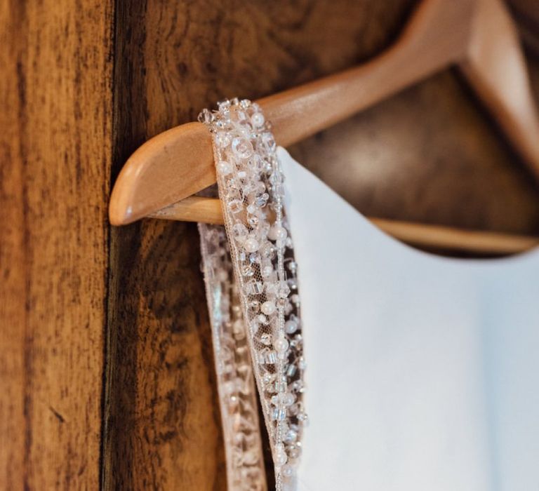 Close up detail of brides embellished gown at same sex woodland wedding celebration  in autumn