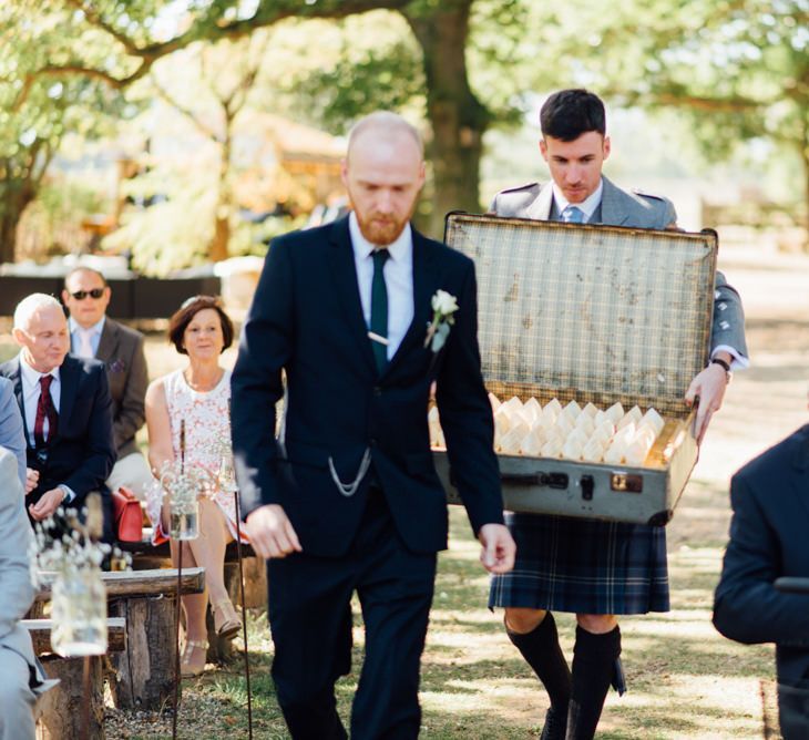 Vintage suitcase with flower confetti at outdoor woodland celebration in autumn