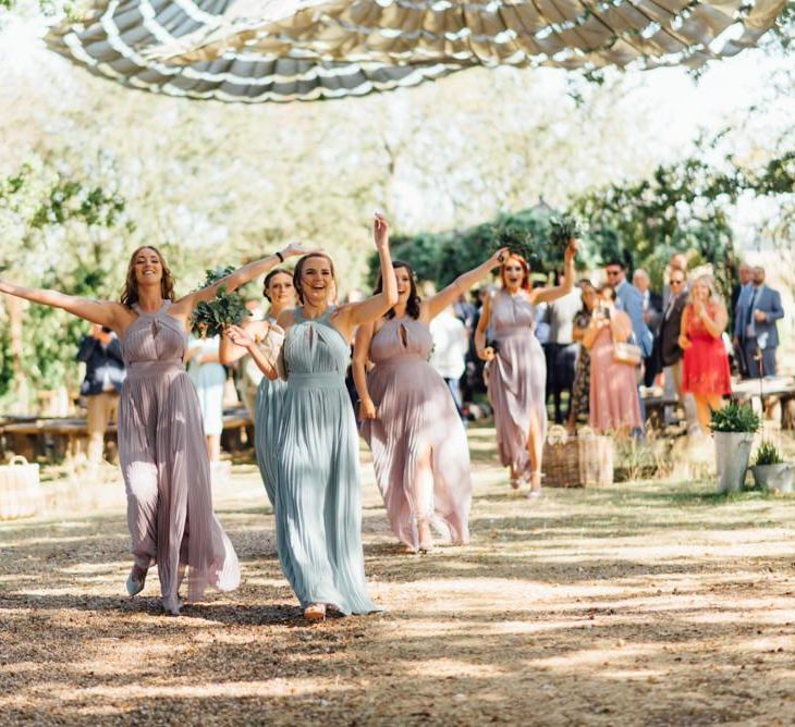 Outdoor woodland wedding celebration with pastel bridesmaid dresses