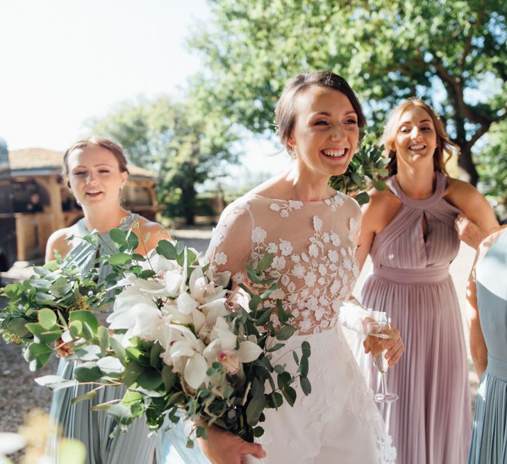 Woodland celebration with pastel bridesmaid dresses and appliqué bridal jumpsuit