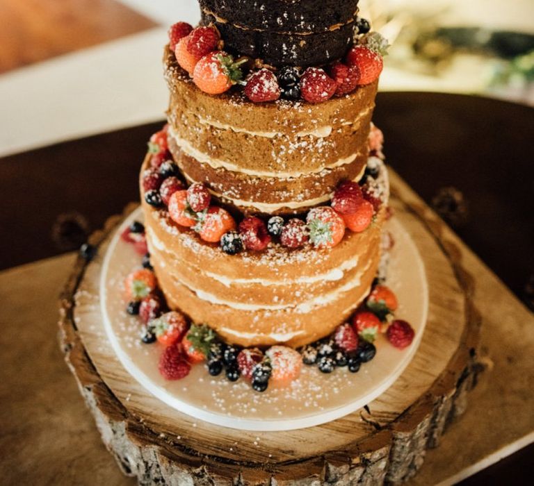 Naked wedding cake with fruit decoration at woodland reception