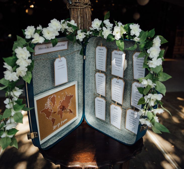 Vintage suitcase table plan at chilled woodland reception in autumn