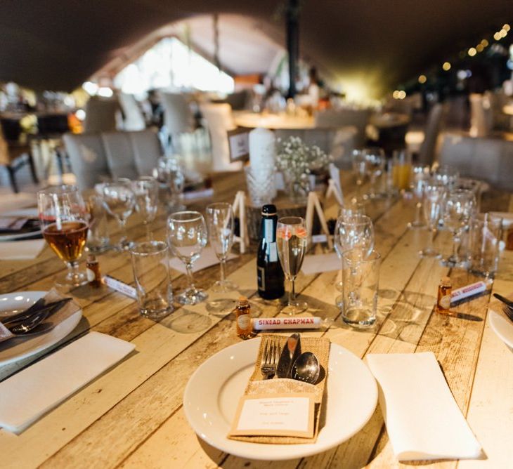 Table decorations kept simplistic with  personalised love heart place settings at woodland styled venue