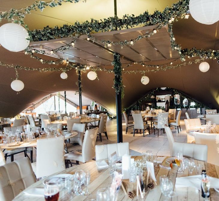 Woodland themed venue decor with fairy lights and hanging paper lanterns