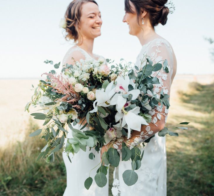 Outdoor autumn woodland celebration with two bridal bouquets