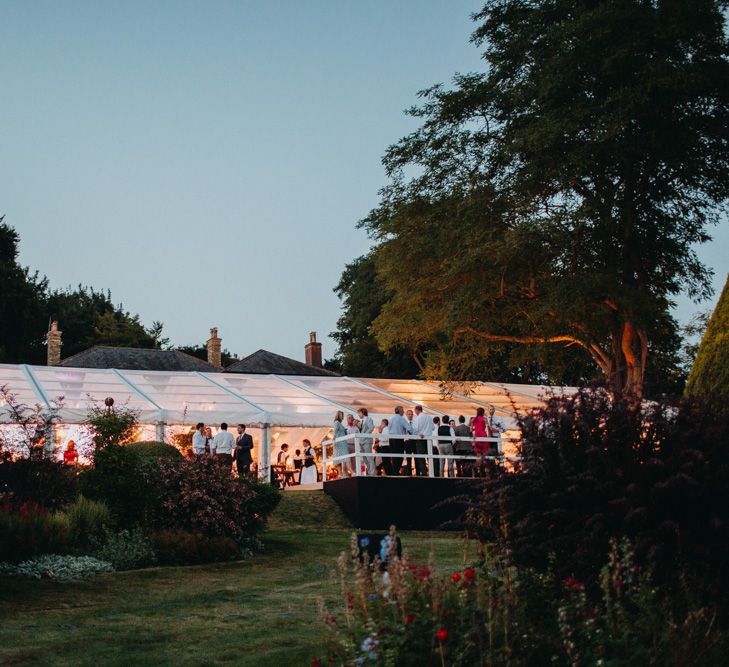 Marquee at Night | Flowers from Topiary Tree | Bride in Karen Willis Holmes | Groom in Custom Made Suit by Suit Supply | Summer Wedding at Family Home in Kent | Glass Marquee from Academy Marquees | Frances Sales Photography