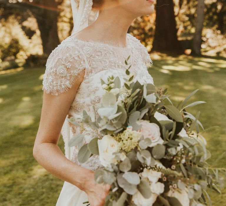 Bride in lace dress with cap sleeves and veil