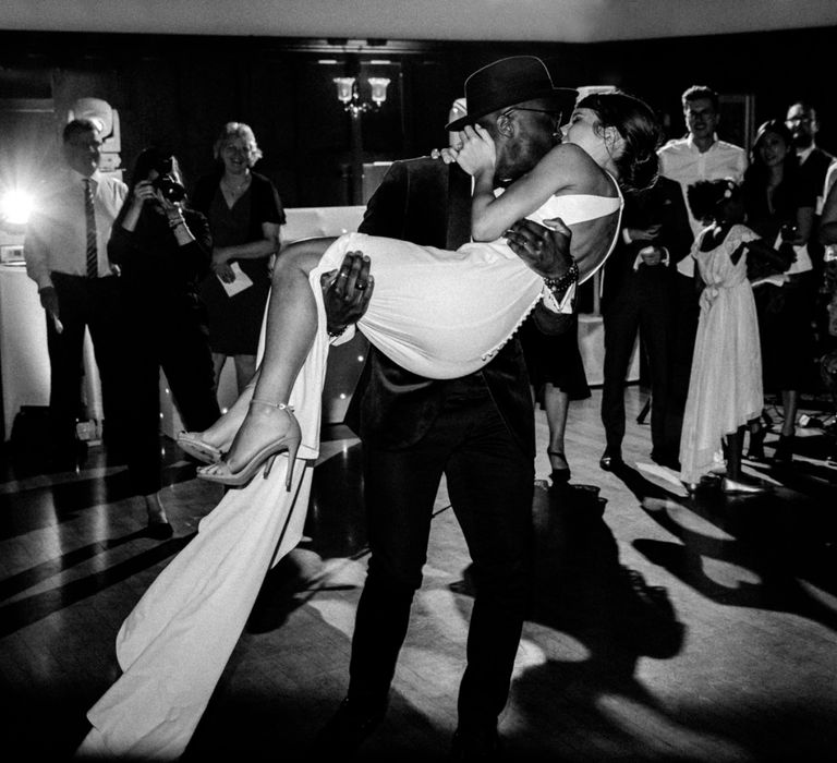 Groom sweeping his bride off her feet at The Ravenswood evening reception