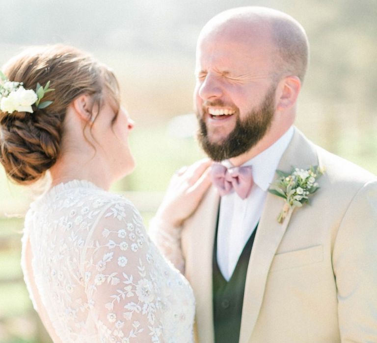 Bride in Needle &amp; Thread Wedding Dress and Groom in Beige Blazer and Pink Bow Tie Laughing Together