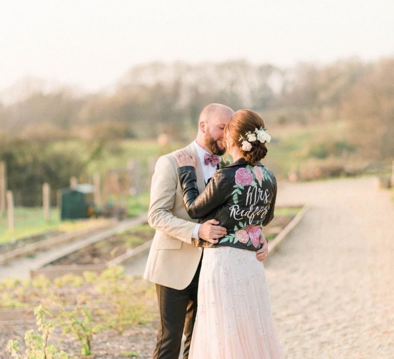 Groom Embracing His Bride in a Handpainted Leather Jacket