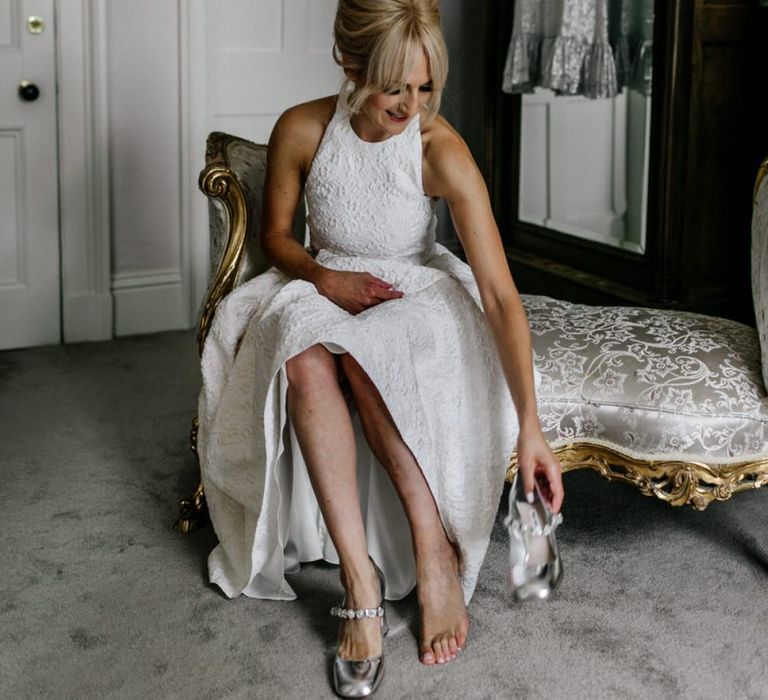 Bride in Charlie Brear Wedding Dress Putting on Miu Miu Shoes