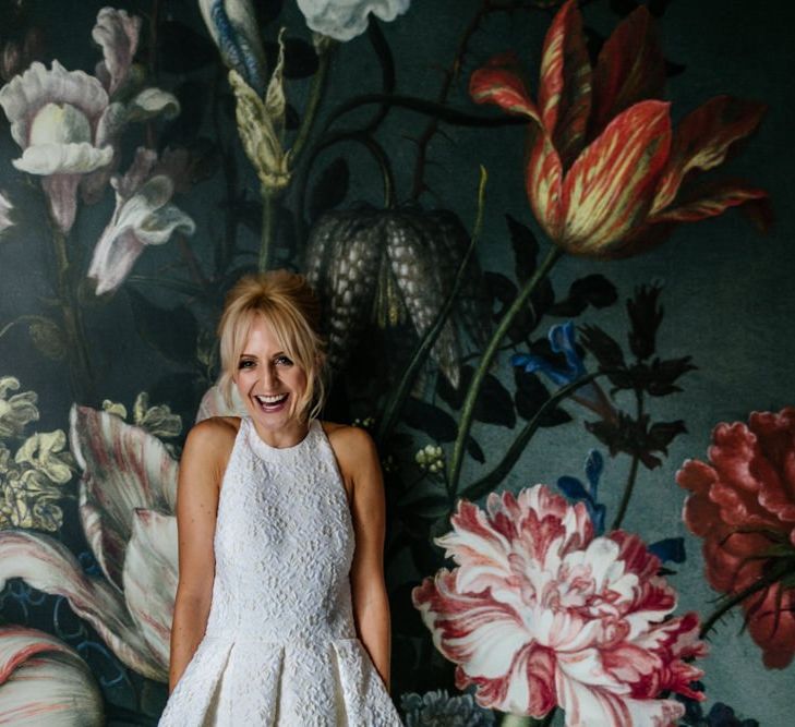 Bride in Charlie Brear Dress Against Painted Flower Wall