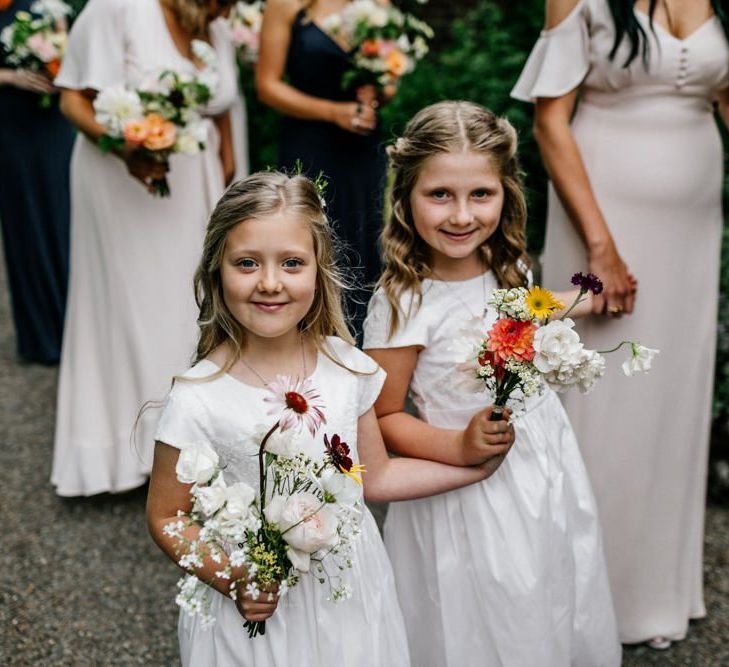 Flower girls holding wedding flowers for ceremony