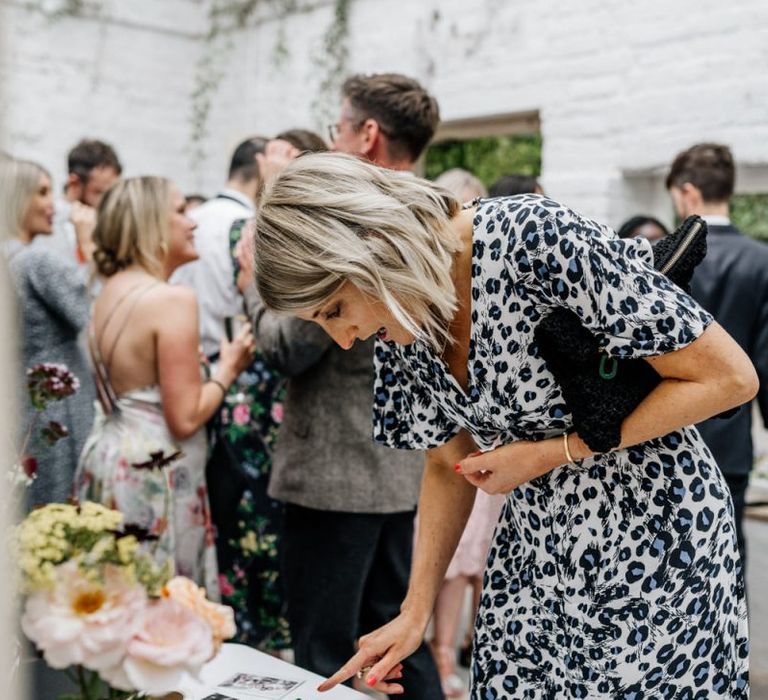 Wedding Guest Looks Through Polaroid Photos At Wedding