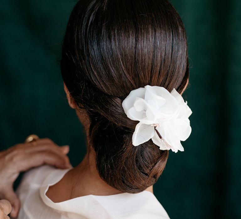 Sleek bridal undo with floral hairpiece