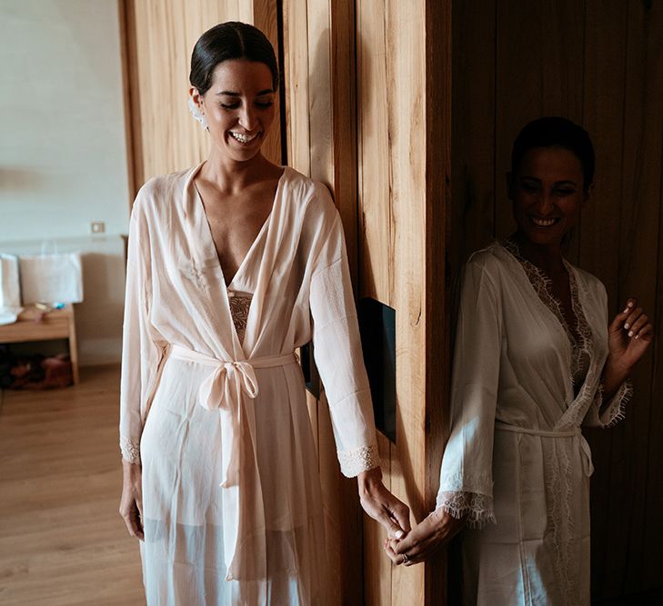 Brides hold hands round curtains at same-sex wedding