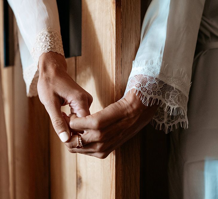 Brides hold hands round curtains at same-sex wedding