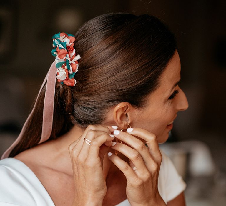 Bridal preparation with floral hairpiece in ponytail