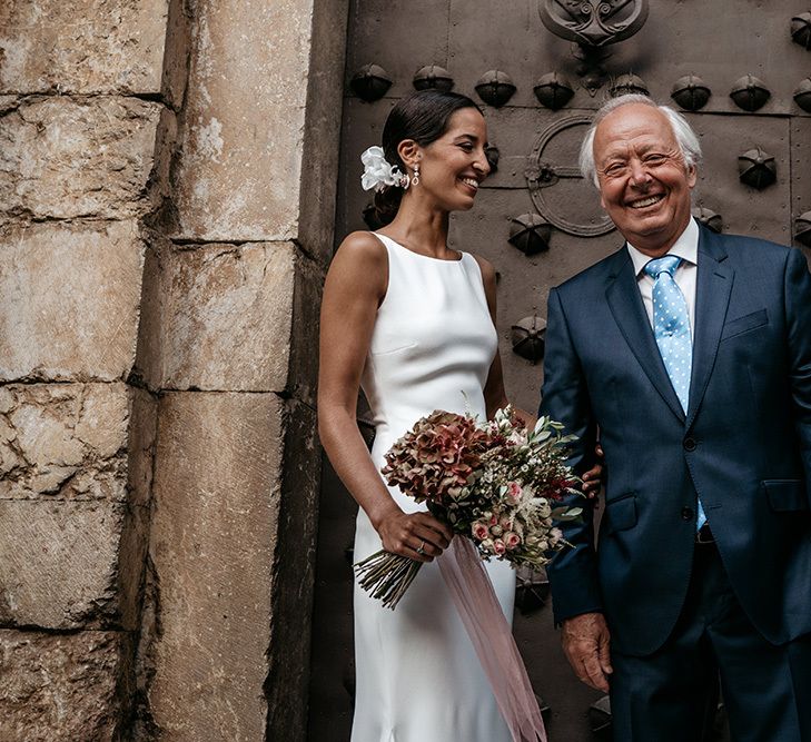 Brides in fitted wedding dresses with Father before outdoor  ceremony