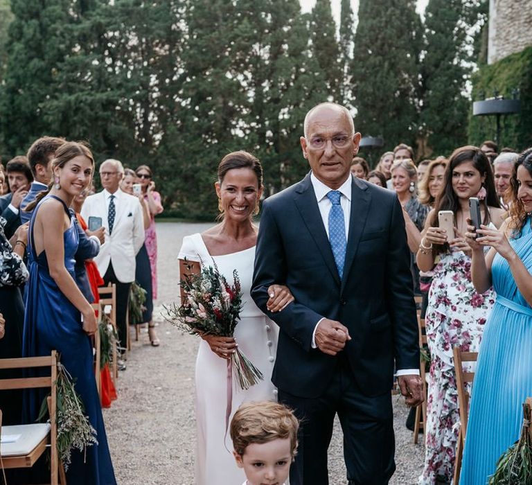 Brides walk down the aisle in  fitted wedding dresses with their Father's