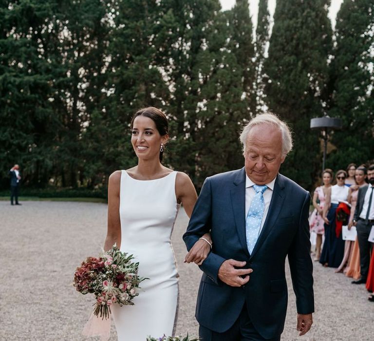 Brides walk down the aisle in  fitted wedding dresses with their Father's