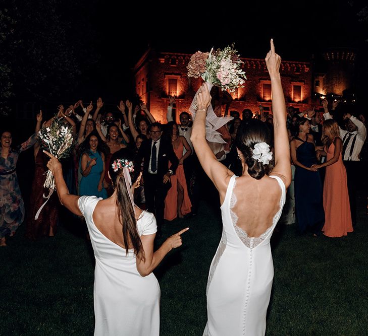 Brides dance during ceremony in fitted wedding dresses