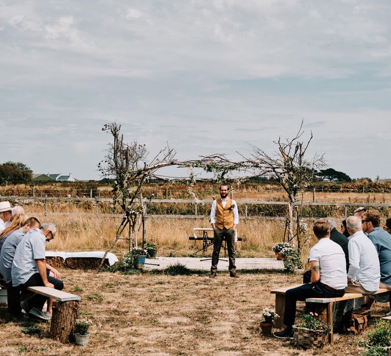 Groom waits for bride at outdoor ceremony in Jersey