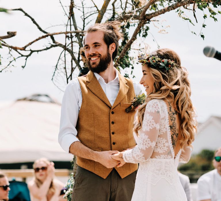 Bride and groom during ceremony with rustic decor and globe guest book