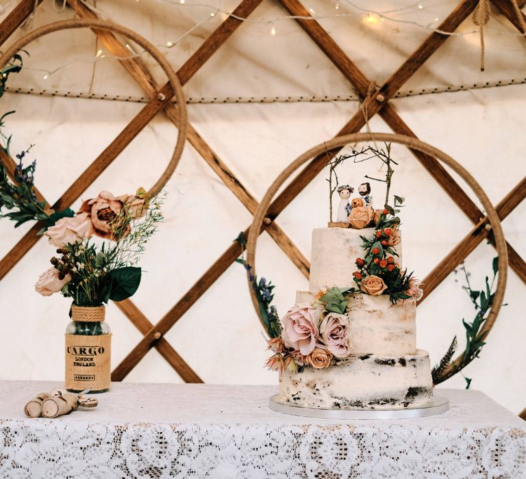 Semi-naked wedding cake with flowers and hoop wedding decor