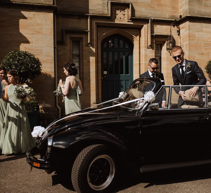 Grooms Getting into VW Beetle Wedding Car