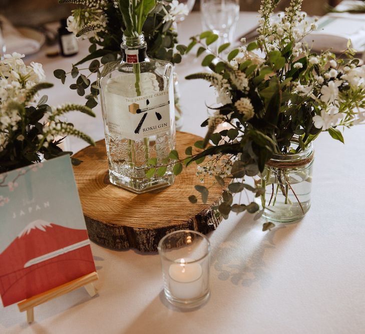 Rustic Centrepiece with Tree Slice, Gin Bottle and White Flowers in Jars