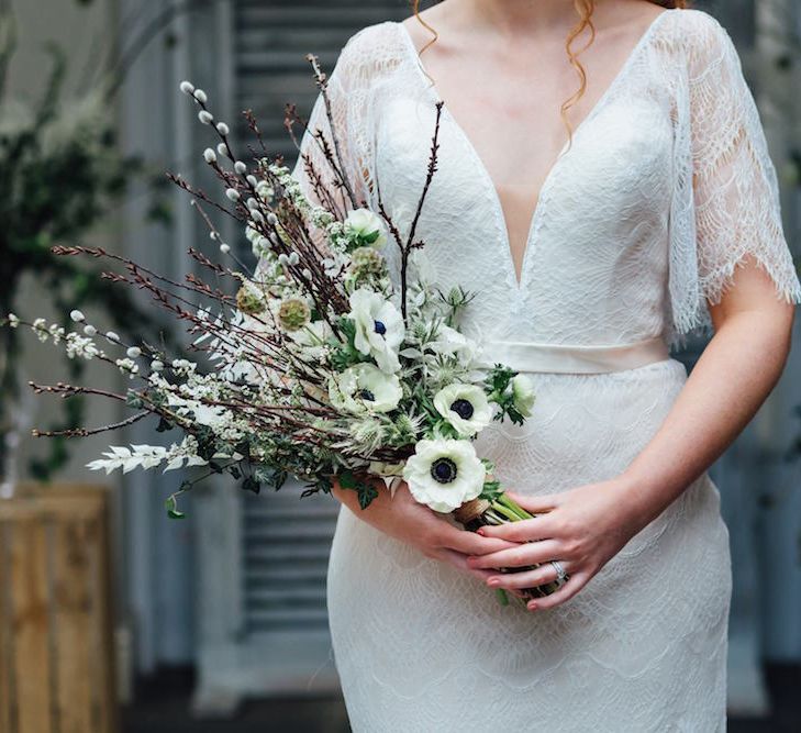 Bride in Lace Batwing Wedding Dress Holding Anemone Bouquet