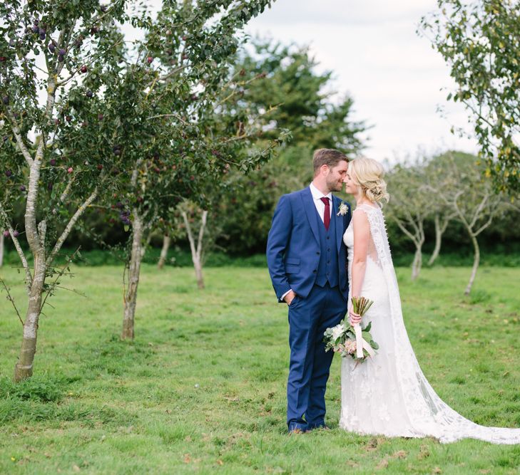 Bride in Claire Pettibone Whitney Bridal Gown with Cape | Groom in French Connection Navy Suit | DIY Country Wedding at Warborne Farm, Lymington | Camilla Arnhold Photography