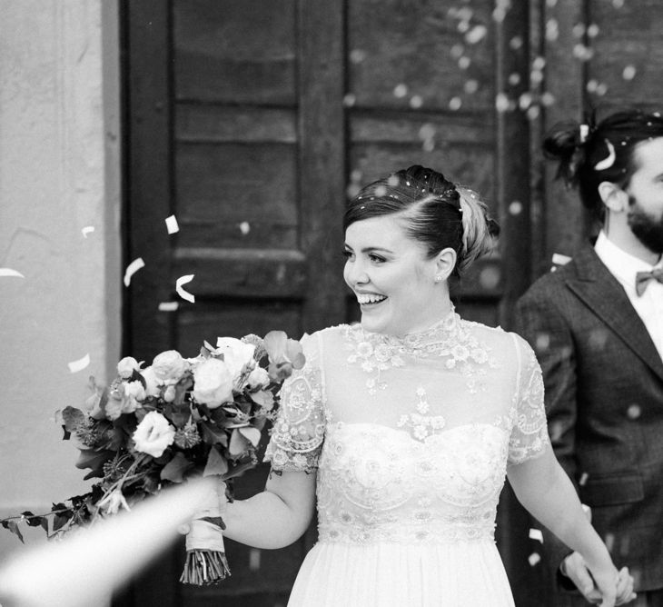 Confetti Exit | Bride in Sartoria Cucciaioni Wedding Dress | Groom in Brown Tweed Suit &amp; Bow Tie | Stylish Pink Wedding at Terzo di Danciano, Tuscany, Italy | Lucrezia Senserini Photography | Film by Righi Photography