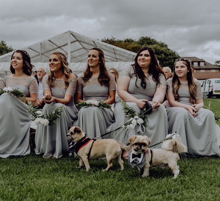 Bridesmaids in Grey ASOS Dresses Sitting on Hay Bales at the Outdoor Wedding Blessing