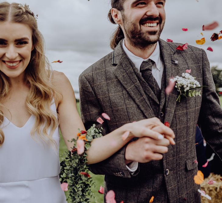 Confetti Moment with Bride in Slip Wedding Dress and Groom in Brown Check Suit