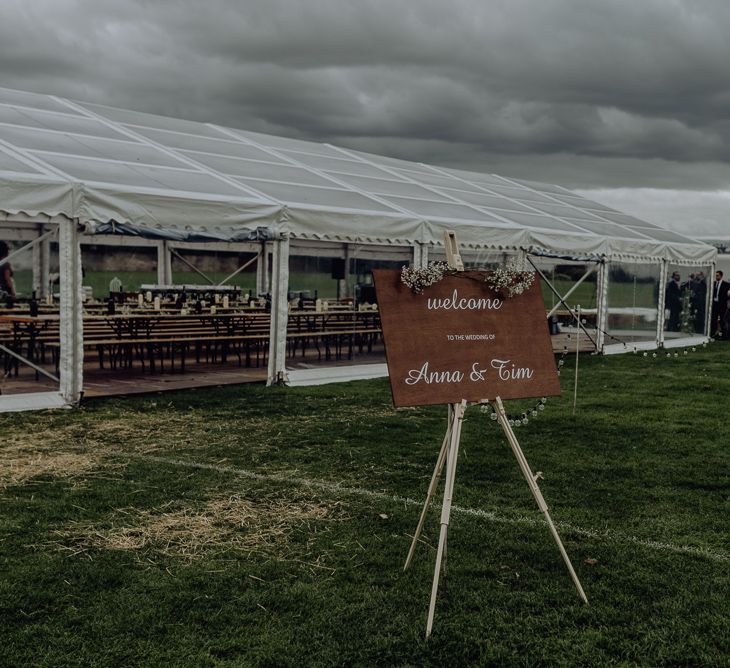 Wedding Welcome Sign on an Easel Outside Clear Sided Marquee Reception