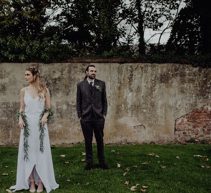 Boho Bride in Slip Wedding Dress and Ivy Garland with Groom in Brown Check Suit