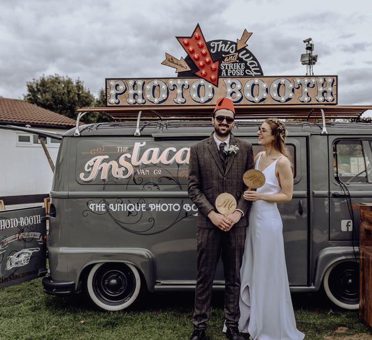 Bride and Groom Standing in Front of Photo Booth Van