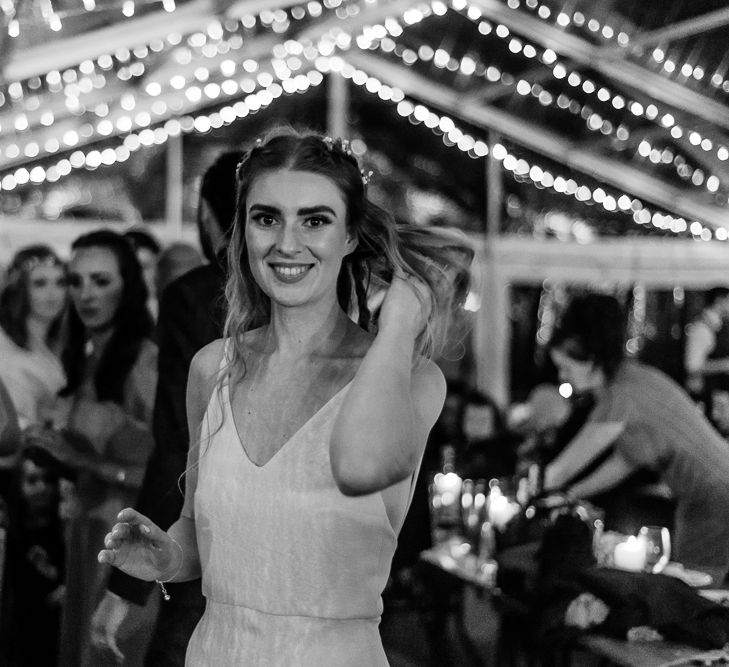 Bride in Wedding Dress with Straps Enjoying Fairy lit Reception