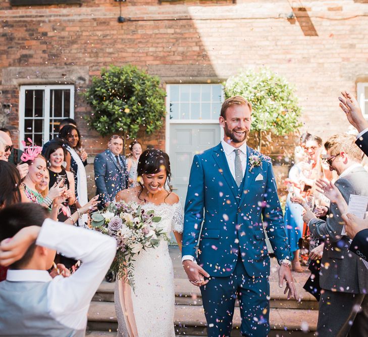 Bride in Lace Watters Dress with Bardot Neckline and Buttons Down Back | Bridal Up Do | Groom in Royal Blue Three-Piece Suit from Moss Bros. with Silver Tie and Pocket Square from T.M.Lewin | Bridal Bouquet of Dusky Pink Roses, White Peonies, Sweetpeas, Coffee-Coloured Phlox and Foliage Tied with Cappuccino Silk Ribbon | Confetti Moment | Smoke Bombs and Chinese Paper Fans Backdrop with Bride in Bardot Dress | Twig &amp; Vine Photography