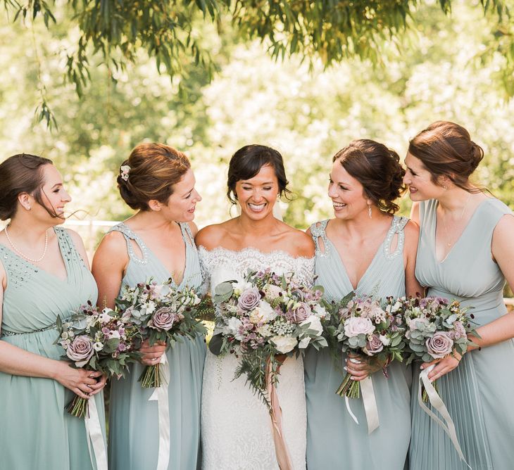 Bride in Lace Watters Dress with Bardot Neckline and Buttons Down Back | Bridal Up Do | Bridesmaids in Sage Green Dresses with Embellished Straps from ASOS | Bridal Bouquet of Dusky Pink Roses, White Peonies, Sweetpeas, Coffee-Coloured Phlox and Foliage Tied with Cappuccino Silk Ribbon | Smoke Bombs and Chinese Paper Fans Backdrop with Bride in Bardot Dress | Twig &amp; Vine Photography